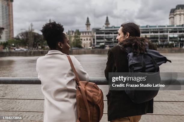 rear view of young friends talking in puerto madero, buenos aires - puerto stock pictures, royalty-free photos & images