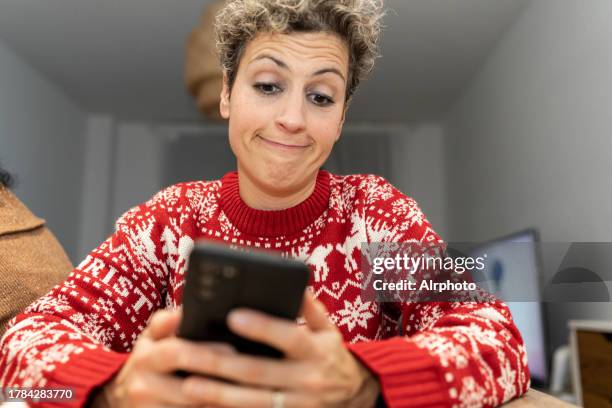 portrait of a mature woman using a mobile phone at home. - sneering stock pictures, royalty-free photos & images