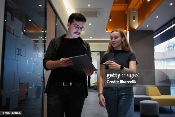 porträt einer jungen unternehmerin und eines mannes, die im büro gehen und brainstormen. konzept für die unternehmenskultur. - brainstormen stock-fotos und bilder