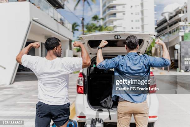 rear view of traveler friends playing doing flexing muscles - testosterone stock pictures, royalty-free photos & images