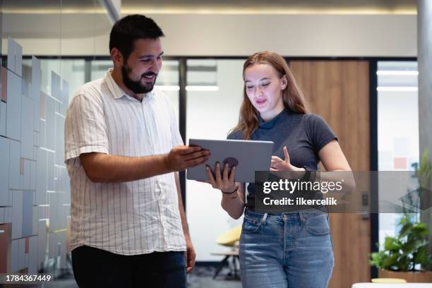 porträt einer jungen unternehmerin und eines mannes, die im büro gehen und brainstormen. konzept für die unternehmenskultur. - brainstormen stock-fotos und bilder