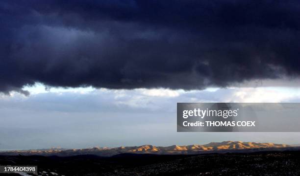 Dark clouds are seen as the sun sets on the Mount of Temptation around the Dead Sea, near the Israeli West Bank settlement of Maale Adumim, 23...