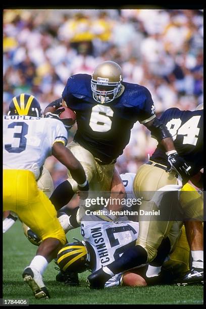 Fullback Jerome Bettis of the Notre Dame Fighting Irish tries to break through the Michigan Wolverines line during a game at Notre Dame Stadium in...