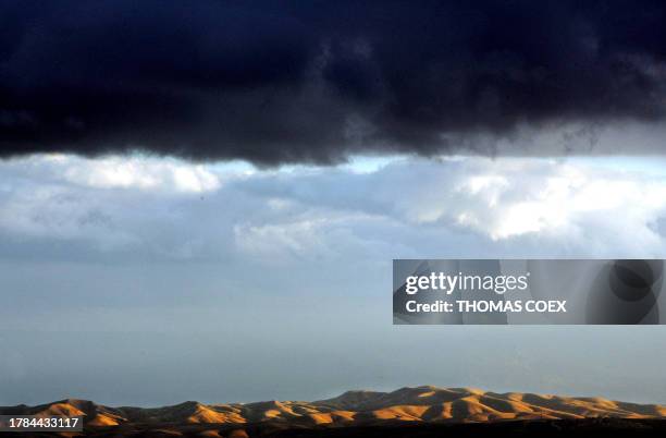 Dark clouds are seen as the sun sets on the Mount of Temptation around the Dead Sea, near the Israeli West Bank settlement of Maale Adumim, 23...