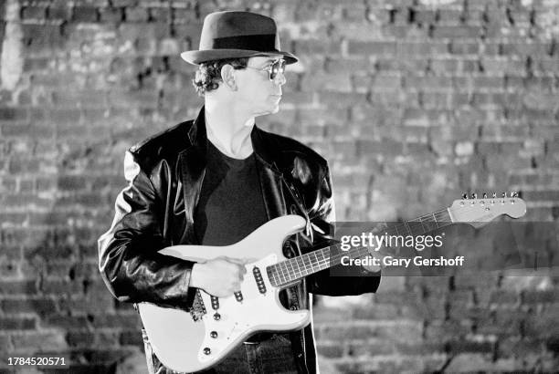 View of American Rock musician Lou Reed , playing a Schecter electric guitar, during a video shoot for his song 'The Original Wrapper' at Zbig...