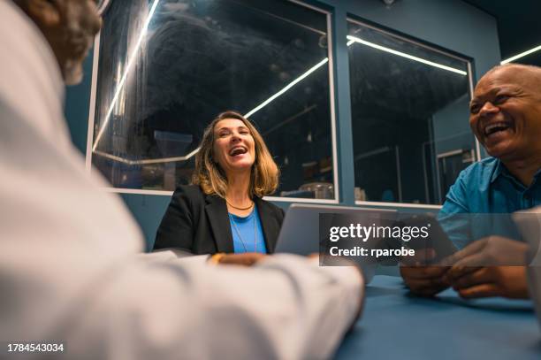 friends smiling at a table in a cafe - work lunch break stock pictures, royalty-free photos & images