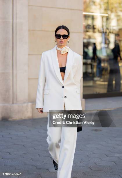 Zina Charkoplia wears white suit by MyBestFriends, black pointed boots Blanc sur Blanc, black Dior bag, Arket flower choker on November 09, 2023 in...