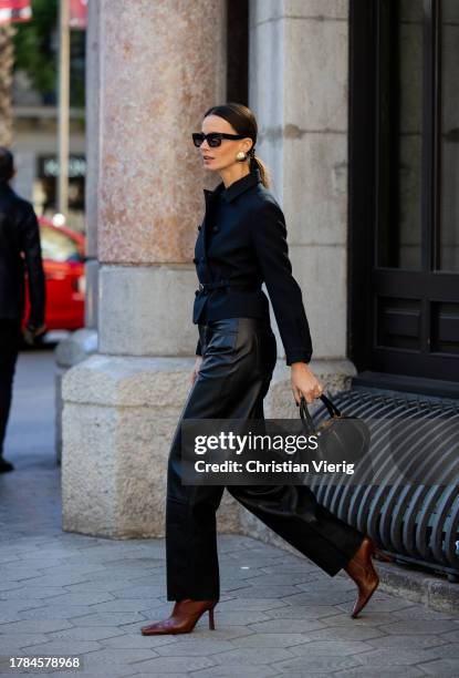 Zina Charkoplia wears black leather pants Lamarque, belted Dior jacket, brown ankle boots Miista, black Dior bag, sunglasses on November 09, 2023 in...