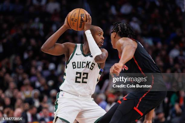 Khris Middleton of the Milwaukee Bucks looks on as Scottie Barnes of the Toronto Raptors defends during the second half of their NBA game at...