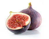 A halved and whole fig isolated on a white background
