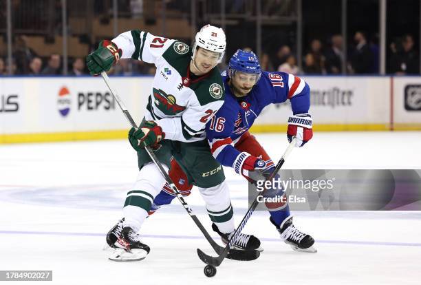 Brandon Duhaime of the Minnesota Wild and Vincent Trocheck of the New York Rangers fight for the puck during the second period at Madison Square...
