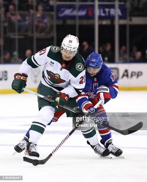 Brandon Duhaime of the Minnesota Wild and Vincent Trocheck of the New York Rangers fight for the puck during the second period at Madison Square...