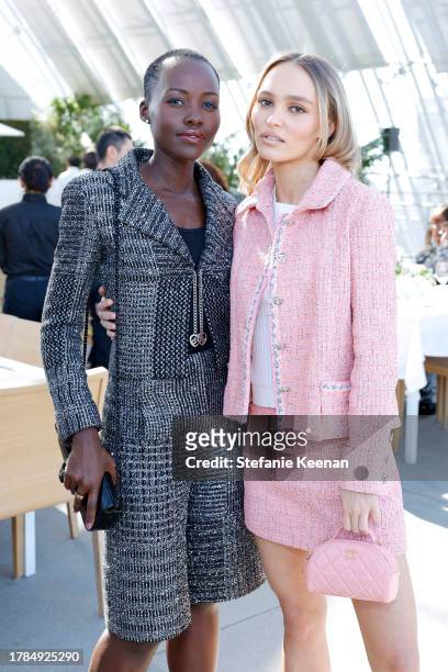 Lupita Nyong'o and Lily-Rose Depp, both wearing CHANEL, attend the Academy Women's Luncheon Presented By CHANEL at the Academy Museum of Motion...