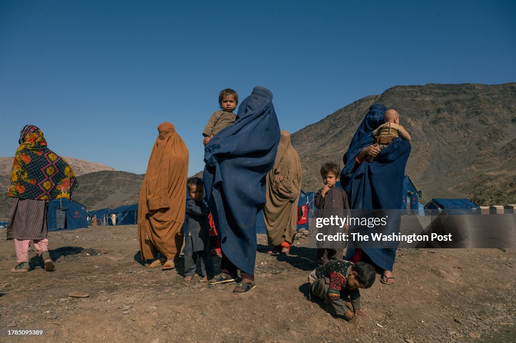 Returnees women and their children stand in a humanitarian camp set near the Torkham border crossing in Eastern Afghanistan...