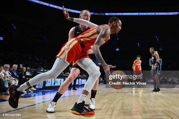 Dejounte Murray of the Atlanta Hawks dribles against Joe Ingles of the Orlando Magic during the game between the Atlanta Hawks and Orlando Magic as...