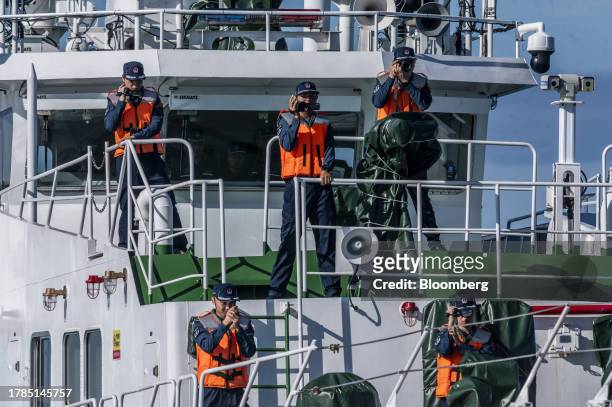Chinese Coast Guard personnel take pictures and videos of Philippine Coast Guard ships during the Philippines Coast Guard's resupply mission to the...