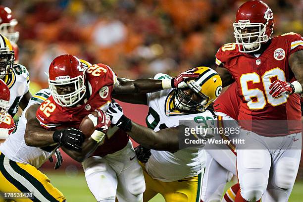 Cyrus Gray of the Kansas City Chiefs stiff arms Josh Boyd of the Green Bay Packers during the last preseason game at Arrowhead Stadium on August 29,...