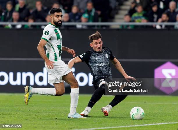 Andi Zeqiri of KRC Genk competes for the ball with Ismael Aaneba of Ferencvarosi TC during the UEFA Europa Conference League Group Stage match...