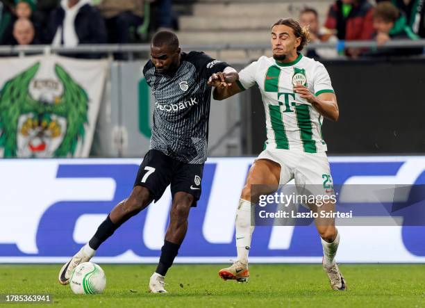 Ibrahim Cissé of Ferencvarosi TC challenges Alieu Fadera of KRC Genk during the UEFA Europa Conference League Group Stage match between Ferencvarosi...