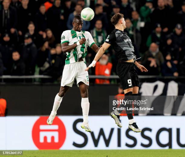 Ibrahim Cissé of Ferencvarosi TC battles for possession in the air with Andi Zeqiri of KRC Genk during the UEFA Europa Conference League Group Stage...