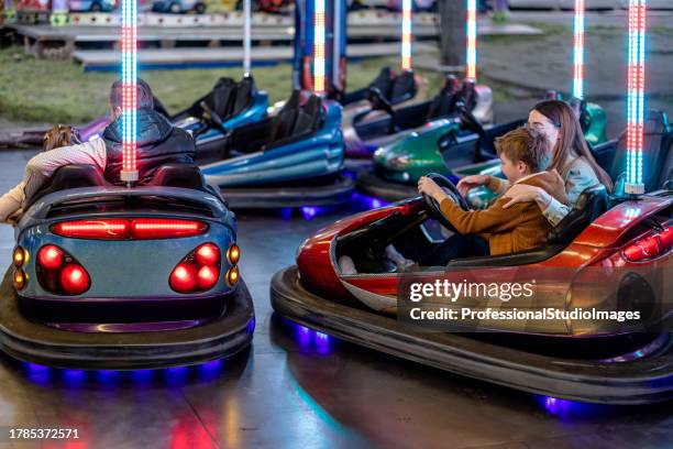 parent et enfant embrassent l’aventure des autos tamponneuses au parc d’attractions - auto tamponneuse photos et images de collection