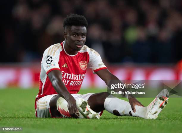 Bukayo Saka of Arsenal sits injured before leaving the pitch during the UEFA Champions League match between Arsenal FC and Sevilla FC at Emirates...