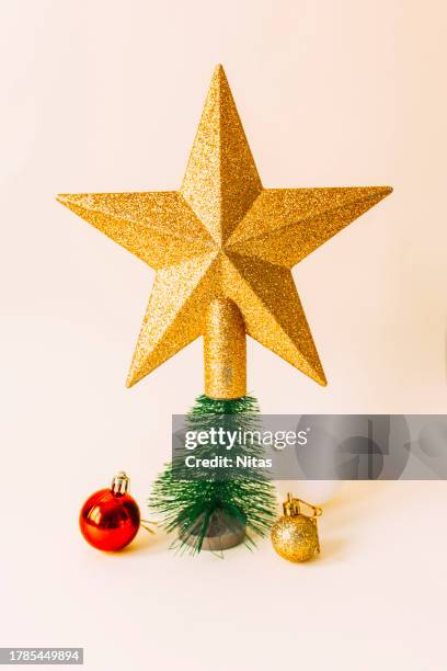 golden star shape with miniature christmas tree and baubles - weihnachtsstern stock-fotos und bilder