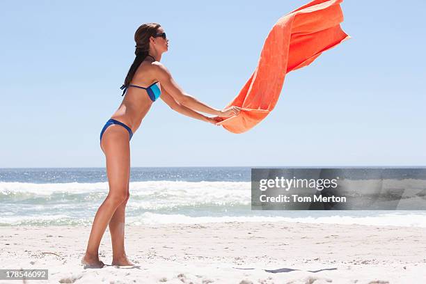 donna in bikini con telo da mare in spiaggia - telo da mare foto e immagini stock