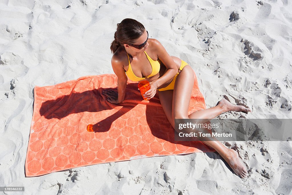 Frau Sonnenbaden am Strand-Handtuch in sand und Getränke