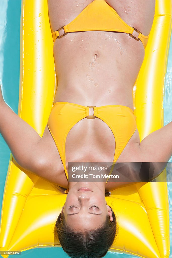 Woman sunbathing on inflatable raft