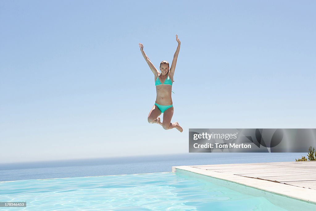 Woman jumping into swimming pool