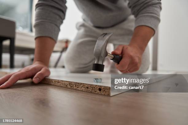 handyman is making cabinets at home - hamer stockfoto's en -beelden