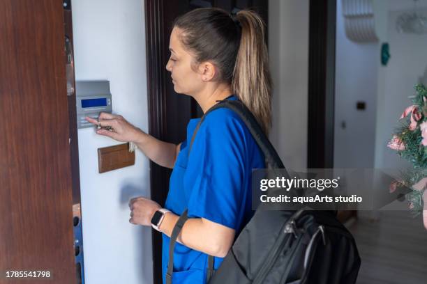 woman with scrubs using a home automation system - pin entry stock pictures, royalty-free photos & images
