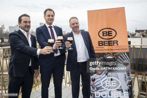 Belgium's Prime Minister Alexander De Croo , CEO of Belgian Brewers Krishan Maudgal and VLAM CEO Filip Fontaine hold a beer as they pose for...