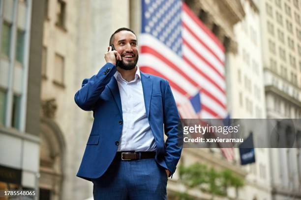 confident financial advisor talking with caller in nyc - american man stockfoto's en -beelden