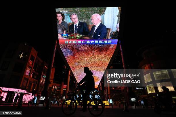 An outdoor screen in Beijing shows a news program about US President Joe Biden meeting Chinese President Xi Jinping during the Asia-Pacific Economic...