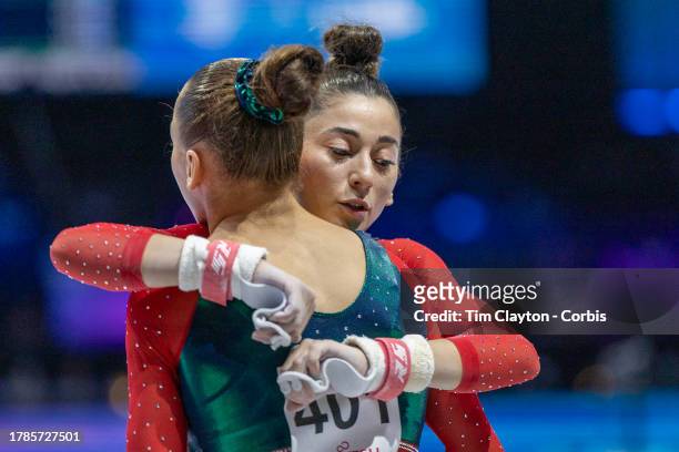 October 02: Lahna Salem of Algeria and Kaylia Nemour of Algeria embrace as they perform their uneven bars routine during Women's Qualification at the...