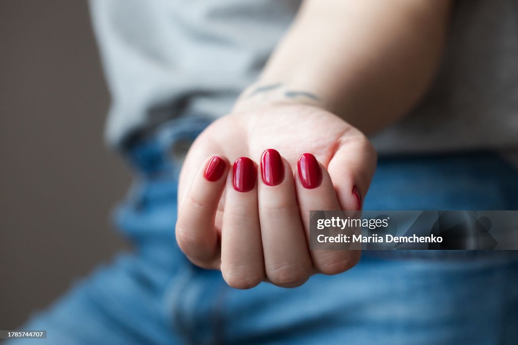 Hand with red gel fingernails