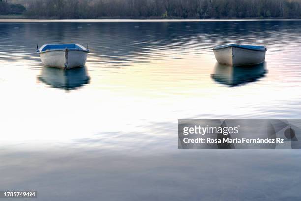 rowboat and reflection in lake of bayonles at sunset.  (estany de banyoles) - banyoles stock-fotos und bilder