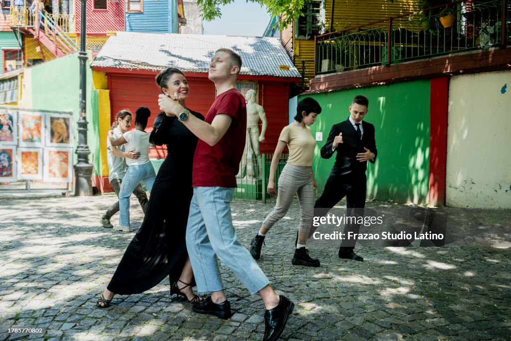 Street artist woman teaching tango to tourist on Caminito, Buenos Aires, Argentina