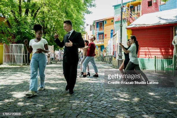 street artist man teaching tango to tourist on caminito, buenos aires, argentina - tango black stock pictures, royalty-free photos & images
