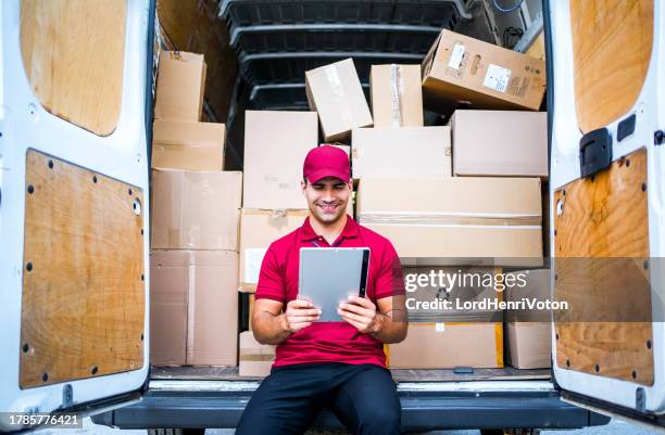 male courier using a tablet while checking the deliveries - summer job stock pictures, royalty-free photos & images