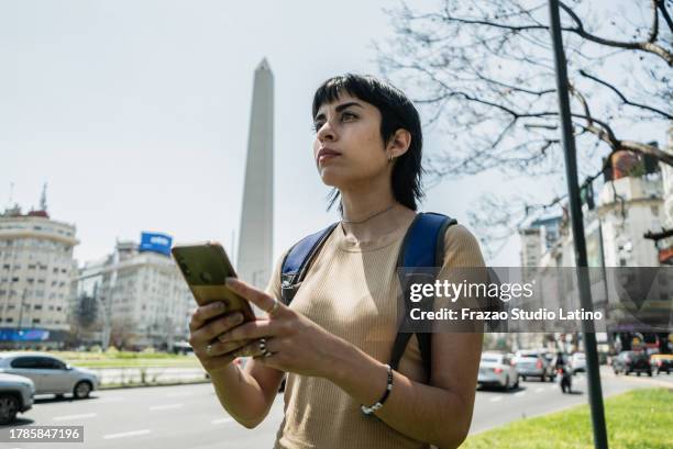 traveler young woman using mobile phone on buenos aires, argentina - uber in buenos aires argentina stock pictures, royalty-free photos & images