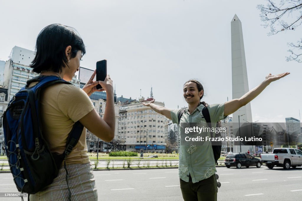 Tourist young woman photographing her friend on Buenos Aires, Argentina