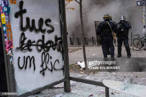 Policiers anti-émeutes à un abribus vandalisé lors de la manifestation des Gilets Jaunes le 5 décembre 2019 à Paris.