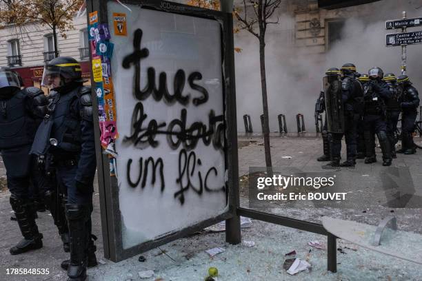 Policiers anti-émeutes à un abribus vandalisé lors de la manifestation des Gilets Jaunes le 5 décembre 2019 à Paris.