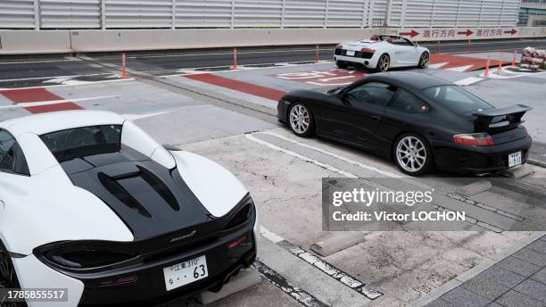 Mclaren 570s, Porsche 911 996 GT3 et Audi R8 spyder sur une aire d'autoroute le 14 mai 2023 à Tokyo.