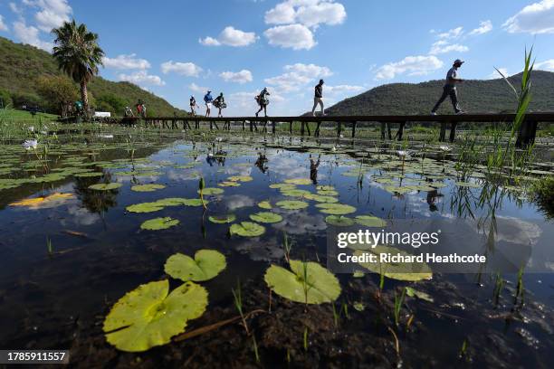 Max Homa of the United States, Ryo Hisatsune of Japan and Julien Guerrier of France walk across a bridge on the 17th hole during Day Two of the...