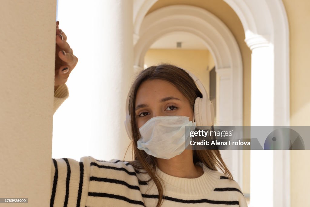 Portrait of beautiful young woman dressing mask