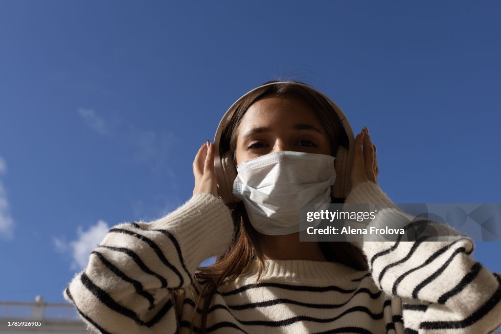 Portrait of beautiful young woman dressing mask